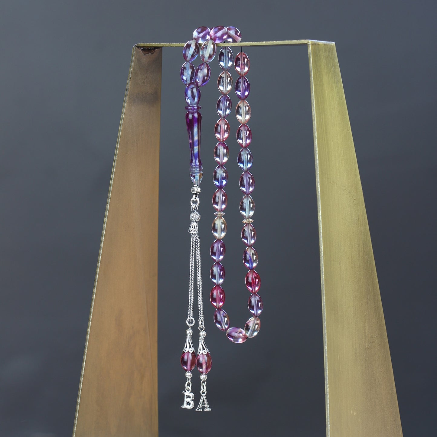 مسبحة كهرمانية مقطوعة من بونبون النار مع حروف مخصصة وشرابات فضية