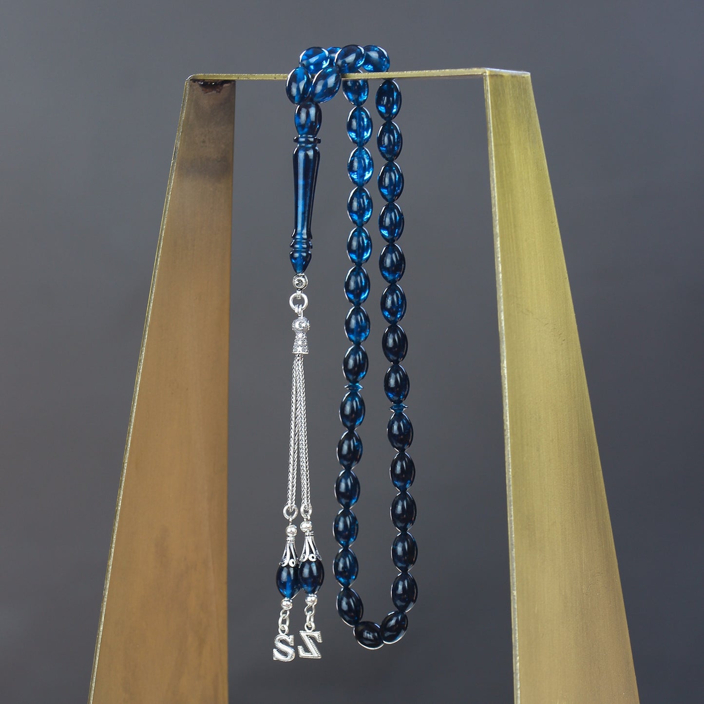 مسبحة من العنبر الأزرق المصفّى بلون الشعير مع حروف مخصصة وشرابات فضية