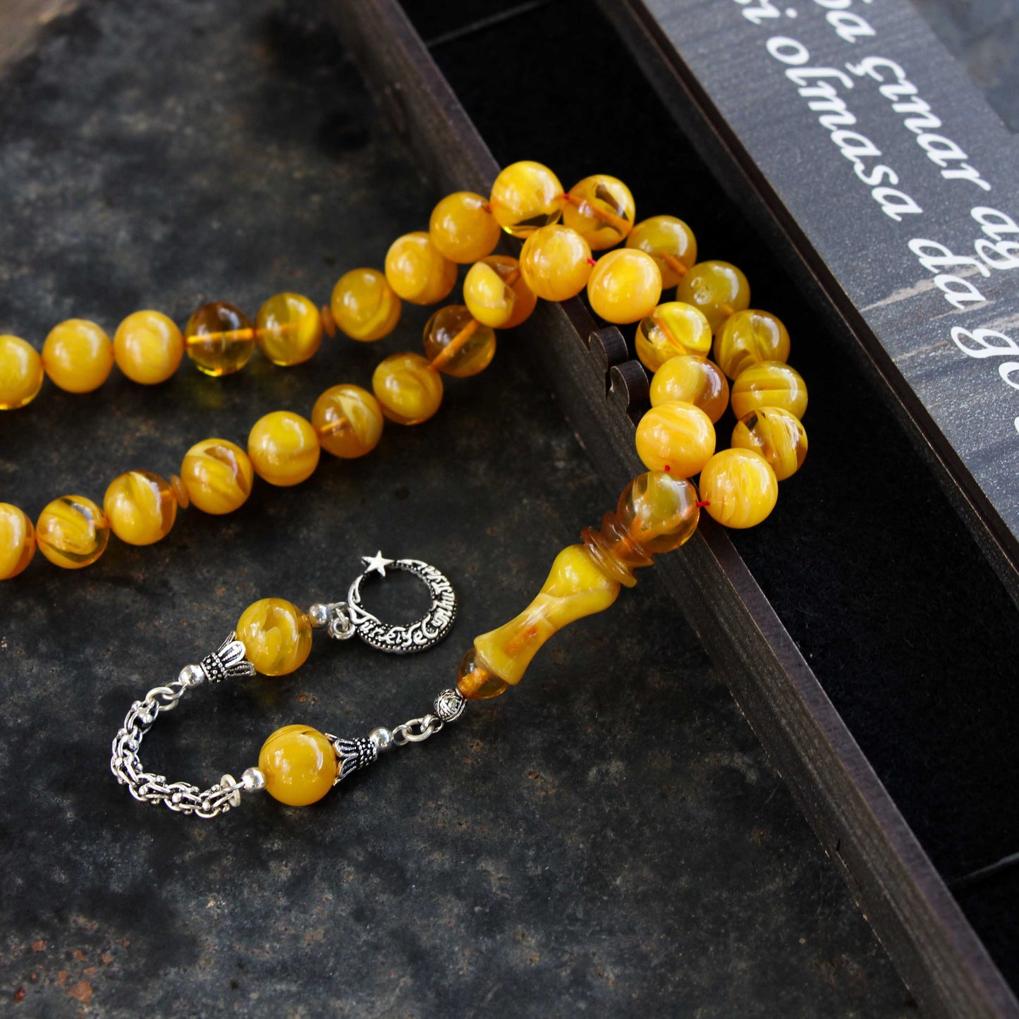 سبحة صلاة من العنبر المضغوط باللون الأصفر مع شرابات فضية ومكتوبة في صندوق مخصص